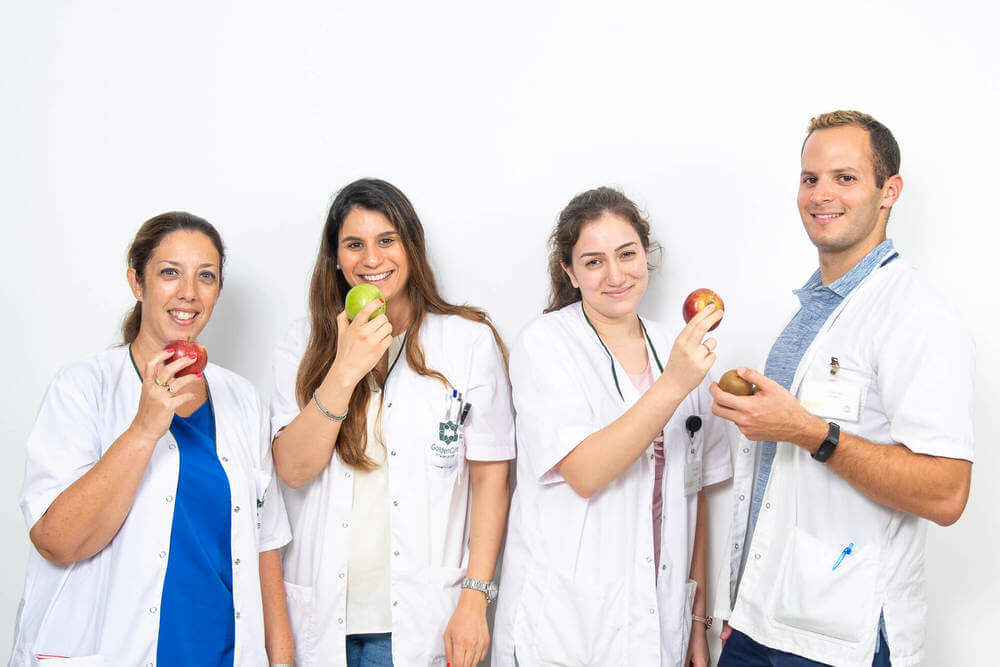 תמונה של הצוות המקצועי עם תפוח ביד - גולדנקייר וג'יקר , מרכזי שיקום, פיזיותרפיה, הידרותרפיה